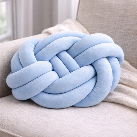 Błękitna poduszka dekoracyjna węzeł knot pillow na fotelu