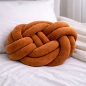 Karmelowa poduszka dekoracyjna węzeł knot pillow na łóżku