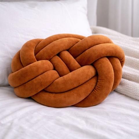Karmelowa poduszka dekoracyjna węzeł knot pillow na łóżku