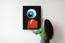 Nowoczesny plakat surrealistyczny z motywem oka w czarnej ramie podczas montażu na ścianie – designerska dekoracja do salonu