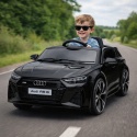 Dziecko jadące czarnym autem elektrycznym Audi RS6 na drodze, samochód na akumulator 12V dla dzieci z napędem 4x4