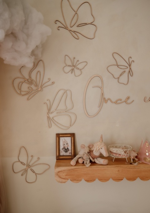Drewniane motyle na ścianę w pokoju dziecka w stylu boho z komodą i drewnianym domkiem
