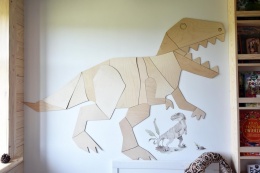 Duża drewniana dekoracja ścienna dinozaur tyranozaur w pokoju dziecka nad półką