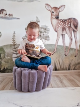 Dziecko siedzące na welurowej pufie dziecięcej – miękkie siedzisko do pokoju dziecka