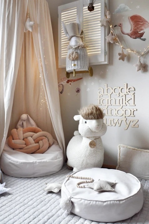 Kremowa pufa dla dziecka w pokoju dziecięcym styl boho miękkie siedzisko