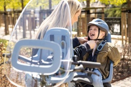 Dziecko w kasku Bobike Denim Deluxe podczas jazdy rowerem w foteliku