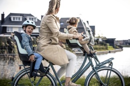 Chłopiec w miętowym kasku dziecięcym Bobike GO podczas rodzinnej przejażdżki rowerowej