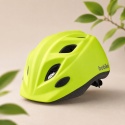 Dziecko w neonowym kasku dziecięcym BOBIKE podczas jazdy na rowerku biegowym