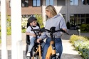 Dziecko w czarnym kasku Bobike podczas jazdy w foteliku rowerowym