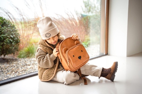 Brązowy plecak dziecięcy Kidzroom z motywem misia w naturalnej aranżacji lifestyle