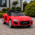 Czerwone Audi R8 na akumulator dla dzieci na podjeździe przed domem