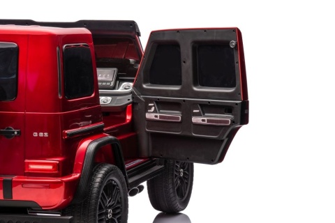 Wnętrze samochodu na akumulator Mercedes G63 dla dzieci z otwartymi tylnymi drzwiami.