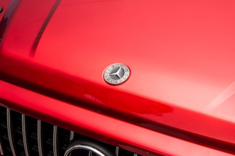 Logo Mercedes na masce czerwonego samochodu na akumulator G63 dla dzieci.