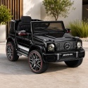 Auto na akumulator Mercedes AMG G63 czarne – elektryczny samochód dla dzieci w ogrodowej aranżacji.