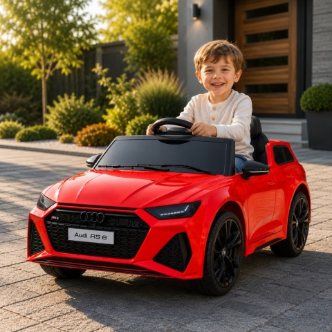 Czerwone Audi RS6 na akumulator dla dziecka podczas zabawy przed domem. Licencjonowany samochód elektryczny dla dzieci.