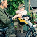 Bobike Mini One Mighty Mustard przedni fotelik rowerowy z osłoną przeciwwiatrową podczas jazdy z dzieckiem