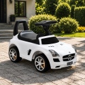 Biały jeździk Mercedes SLS AMG dla dzieci ustawiony na podjeździe przed domem