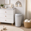 Szary kosz na pieluchy Shnuggle Eco-Touch obok komody z przewijakiem w pokoju niemowlęcia