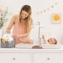 Niemowlę na macie do przewijania Shnuggle Squishy Ivory podczas codziennej pielęgnacji