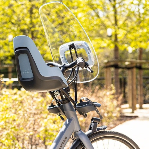 Fotelik rowerowy Bobike MINI ONE Blue z przednią osłoną przeciwwiatrową zamontowany na rowerze