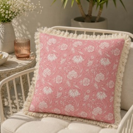 Różowa poszewka ogrodowa GAIA Pink Flower 45x45 cm z frędzlami na fotelu tarasowym w aranżacji boho