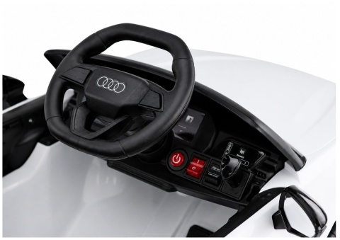 Kierownica z logo Audi oraz panel sterowania w samochodzie elektrycznym Audi A5L dla dzieci.