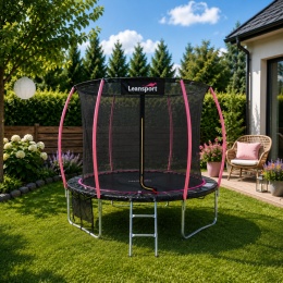 Różowa trampolina ogrodowa z siatką bezpieczeństwa ustawiona w przydomowym ogrodzie