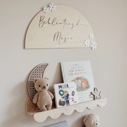 Personalizowana drewniana tabliczka Biblioteczka z imieniem i białymi kwiatkami nad półką na książki w pokoju dziecka