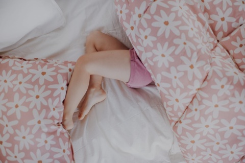 Różowa pościel bawełniana Blush Daisies w białe stokrotki z karmelowymi środkami, zbliżenie na wzór i materiał.