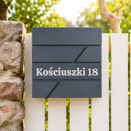 Nowoczesna skrzynka na listy w kolorze antracytowym z napisem adresowym Kościuszki 18 i wbudowanym gazetnikiem